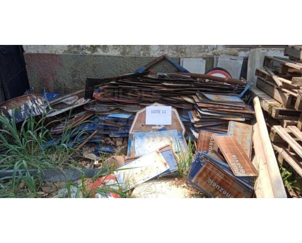Foto de Sucatas composta por motores, peças de veículos e placas de trânsito.